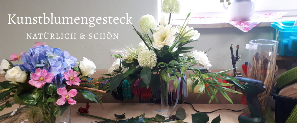 Arbeitstisch mit Kunstblumengesteck und Klebepistole zum...