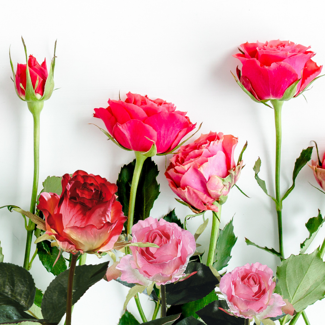 künstliche Rosen Blüten rosa in Glasvase auf Tisch