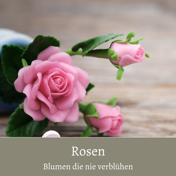 Künstlicher Rosenzweig mit Blüten rosa auf liegt auf Holztisch