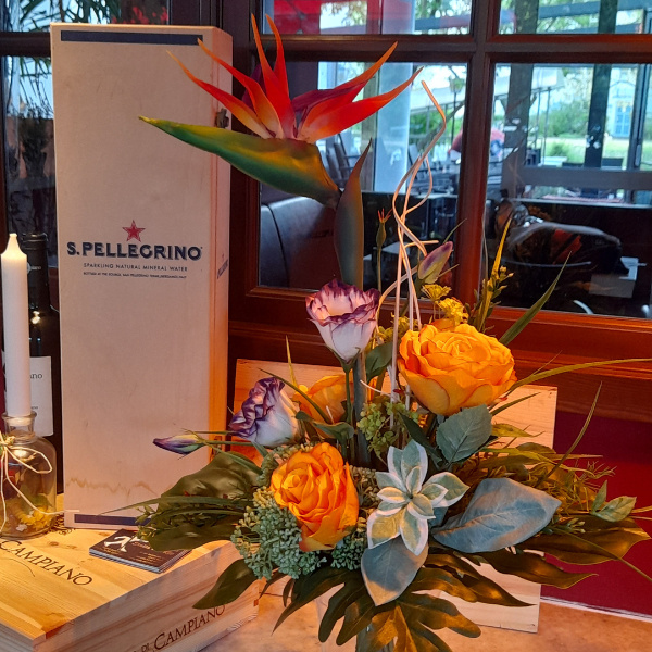 Restaurant im Sommer mit künstlichen Strelitzen Blumenstrauß auf dem Tisch