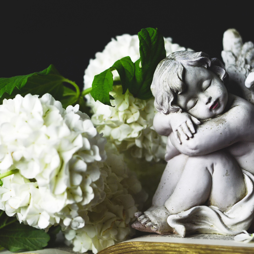 Künstliche Trauerblumen weiß mit Keramikengel auf Grab