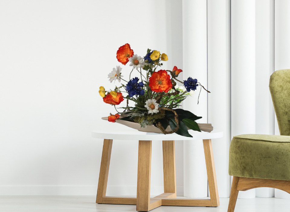 Kunstblumengesteck mit Wiesenblumen Mohn Margeriten und Kornblumen in Keramikschale auf Beistelltisch