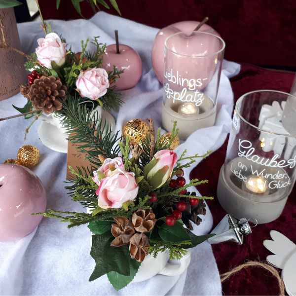 Weihnachtsdeko mit Kunstblumen auf Festtafel mit gold Kugeln
