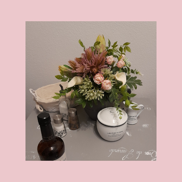 Rosa weißer Kunstblumenstrauß exotisch auf vintage Esstisch
